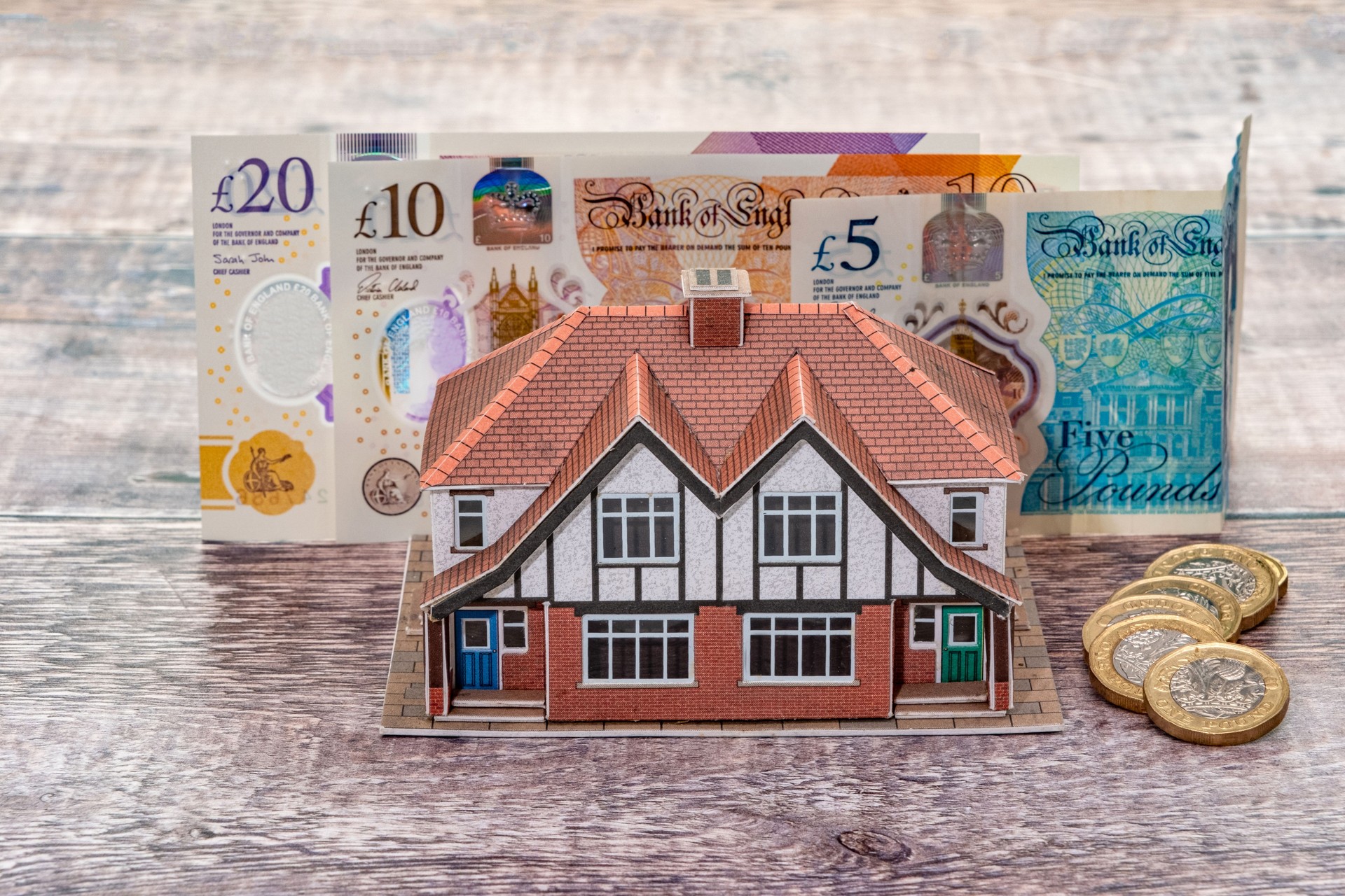 House standing in front of UK pound banknotes